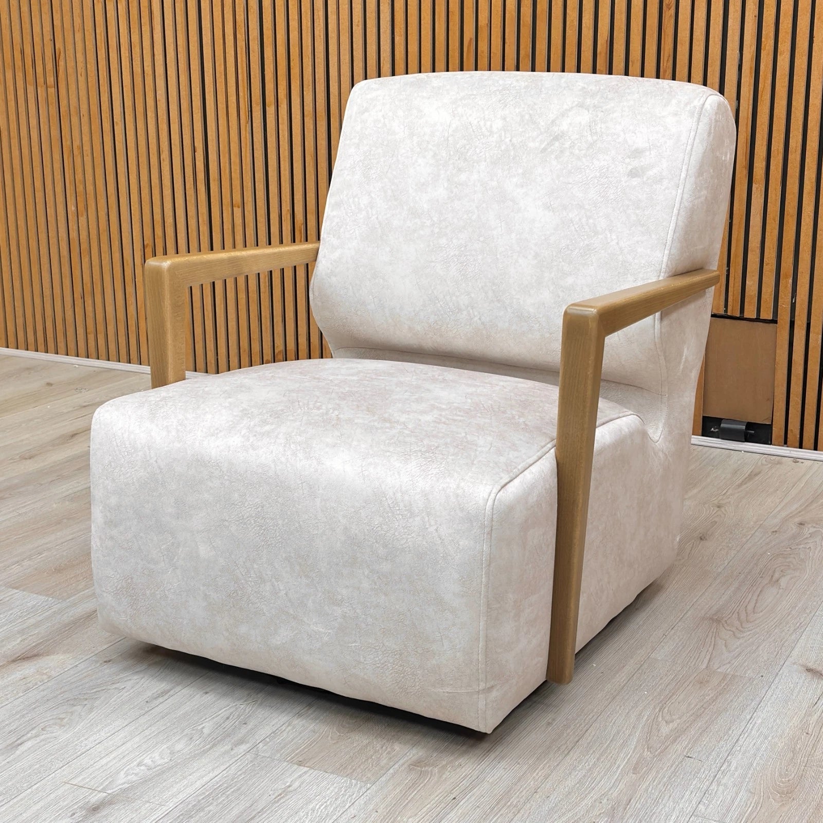 Lifestyle shot of the Kenzo Cream velvet swivel chair in a cozy living room nook, showcasing its elegant design and medium comfort level.
