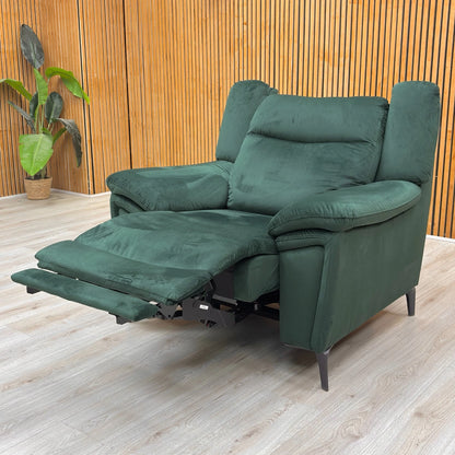 Lifestyle shot of the bottle green velvet recliner armchair highlighting the sleek open-base design and metal legs.