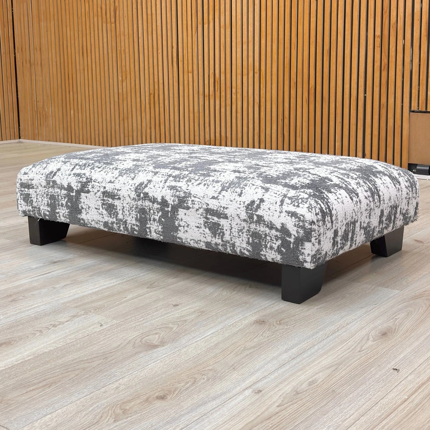 Lifestyle shot of the Kai Grey chenille footstool in a living room setting, showcasing its elegant addition to contemporary home decor.