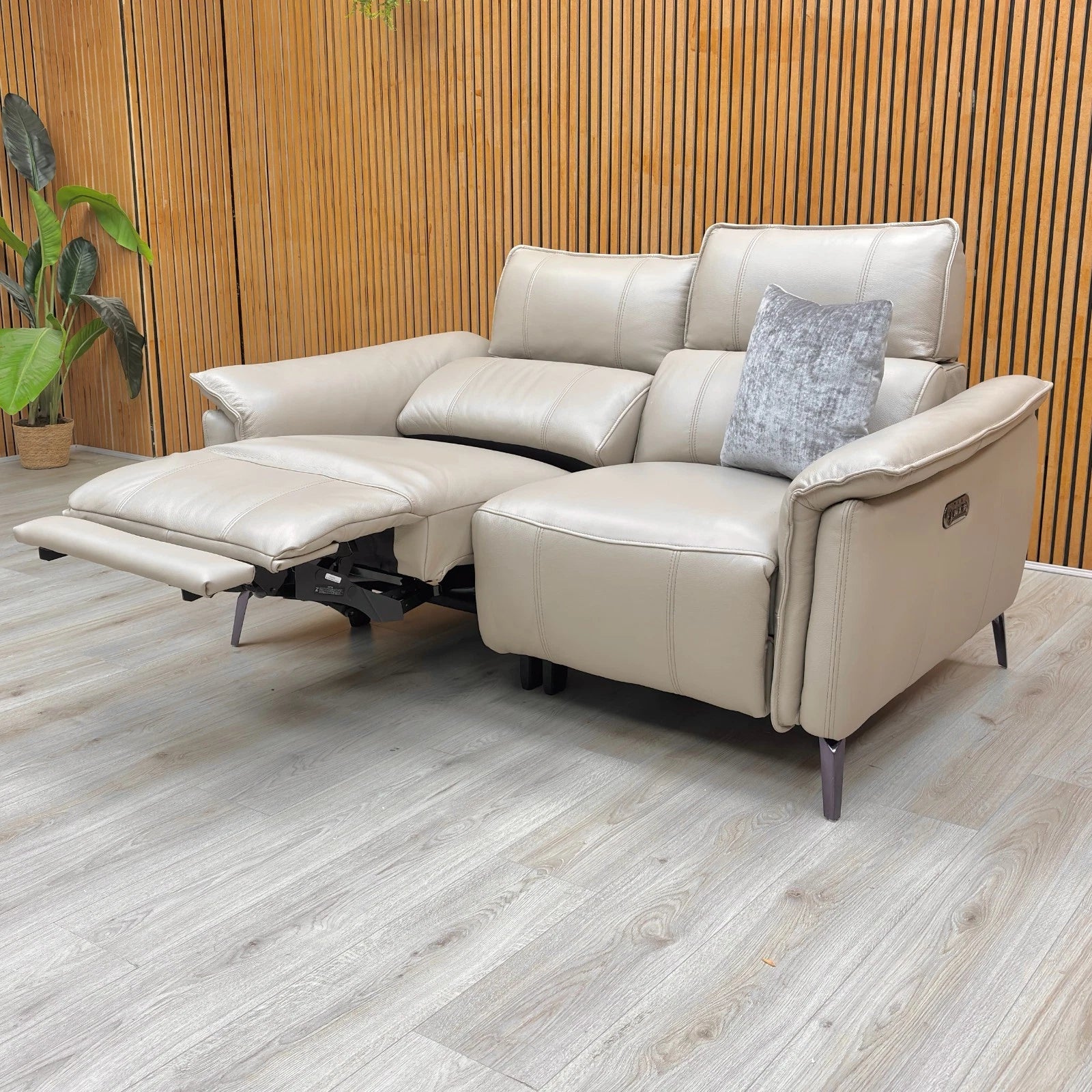 Lifestyle shot of the ‘Jude’ leather recliner sofa in a living room setting, showcasing the power headrests and gunmetal grey legs.