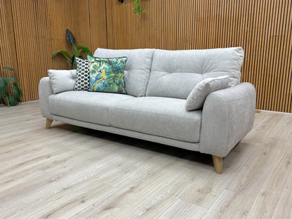 Lifestyle shot of the Malmo sofa, showcasing the gentle curves and buttoning detail on the back.