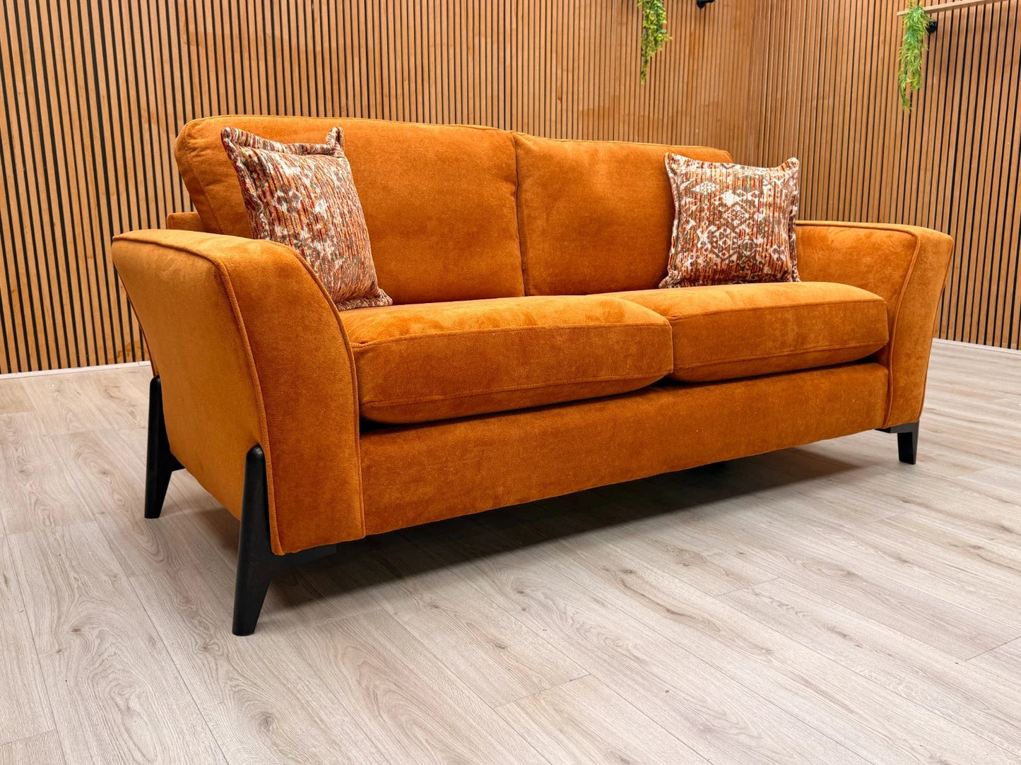 Side view of the 'Collins' sofa, clearly showing the continuous line of the sloped armrest and the generous depth of the seating.