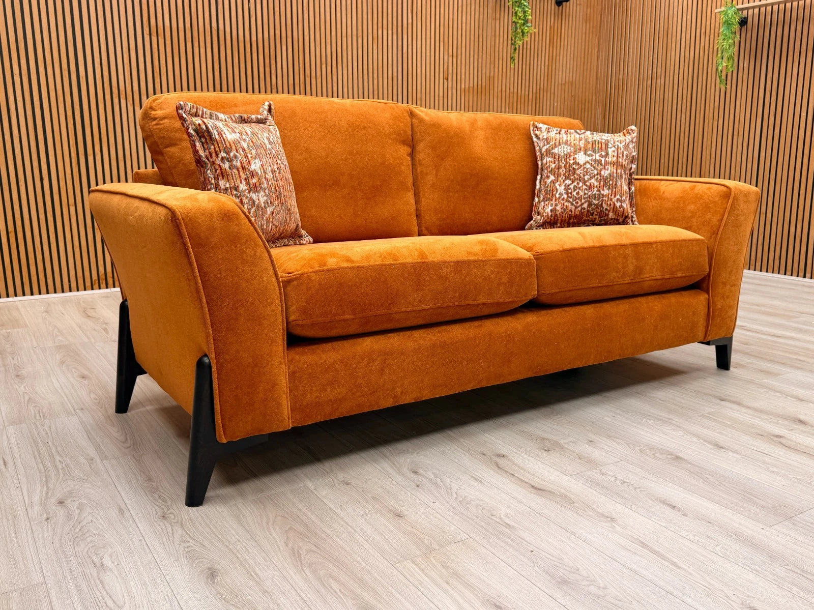 Side view of the 'Collins' sofa, clearly showing the continuous line of the sloped armrest and the generous depth of the seating.