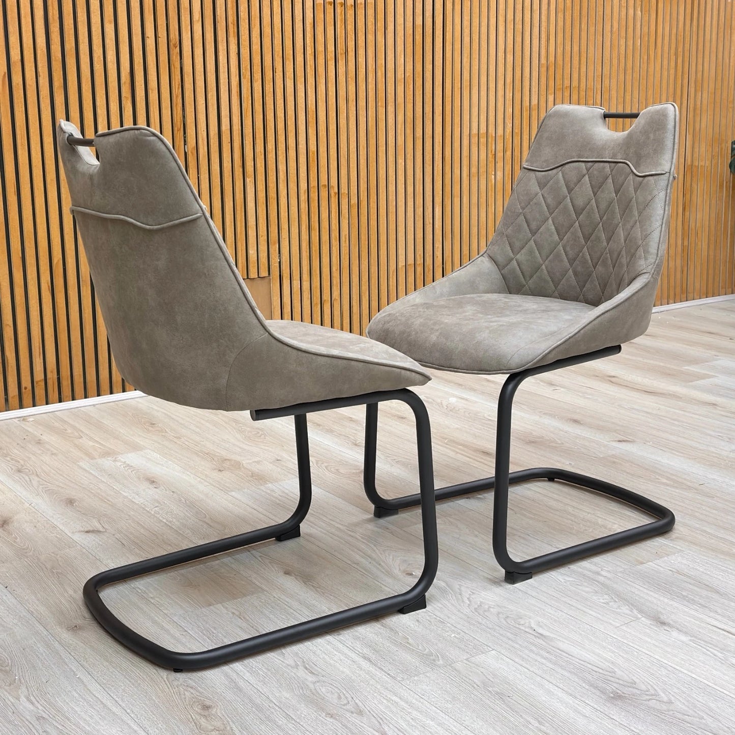 Lifestyle view of the taupe dining chair highlighting the curved back and cantilever base.