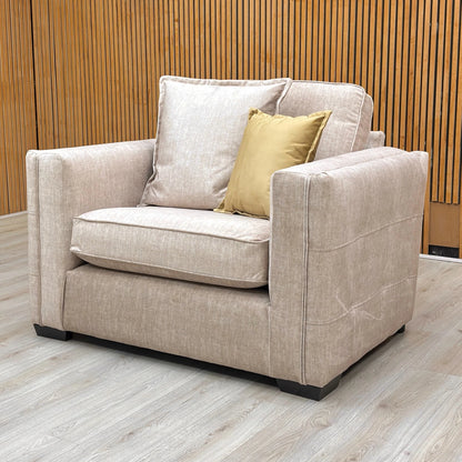 Side angle of the beige velvet Chelsea snuggler chair, showcasing its wide "love seat" seating area and modern English arm style.