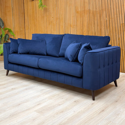 Lifestyle shot of the Royal Blue ‘Remy’ 4-seater sofa, showcasing its large seating capacity and elegant, bold presence in a living room.