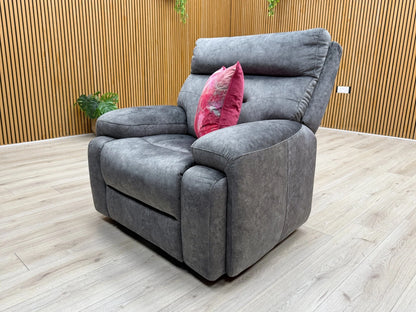 Stylized lifestyle shot of the ‘Cinemax’ dark grey velvet chair, highlighting its generous body-hugging curves.