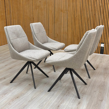 Full-view close-up of a single ‘Jasmine’ Latte Fabric Swivel Dining Chair, highlighting the textured fabric and the four-pronged black metal swivel base.