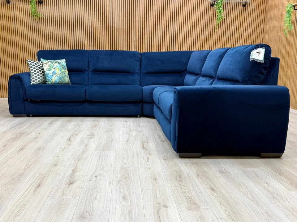Angled view of the Navy Velvet Corner Sofa, showcasing its large footprint, deep seats, and wide, rounded armrests.