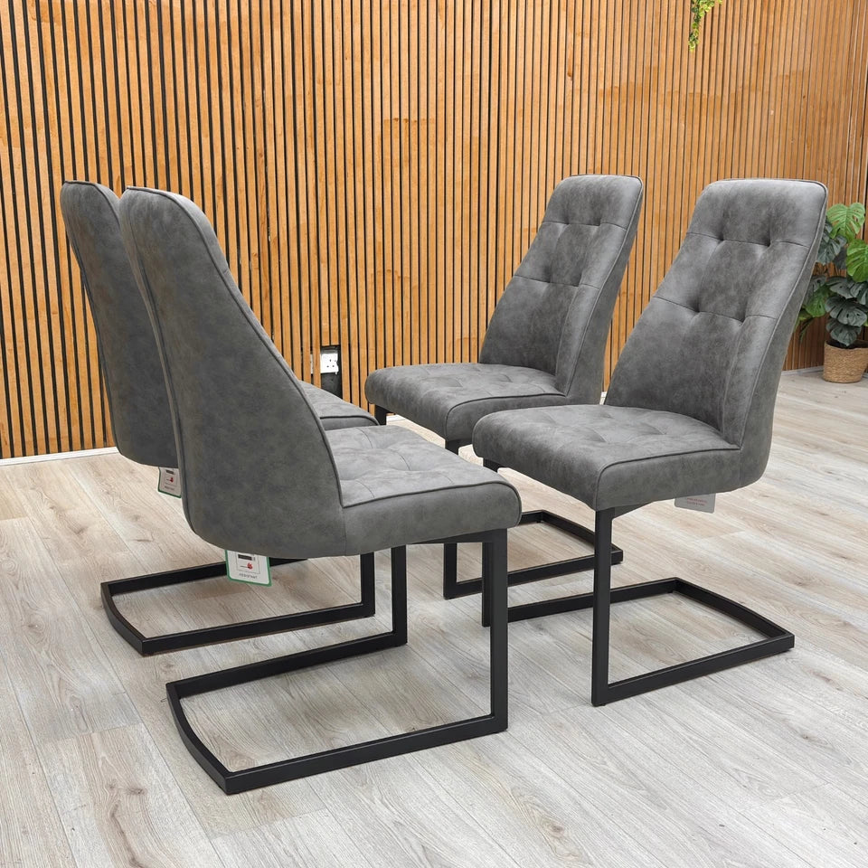 Lifestyle shot of the Charcoal Grey Suede dining chairs in a dining room setting, complementing a modern dining table.
