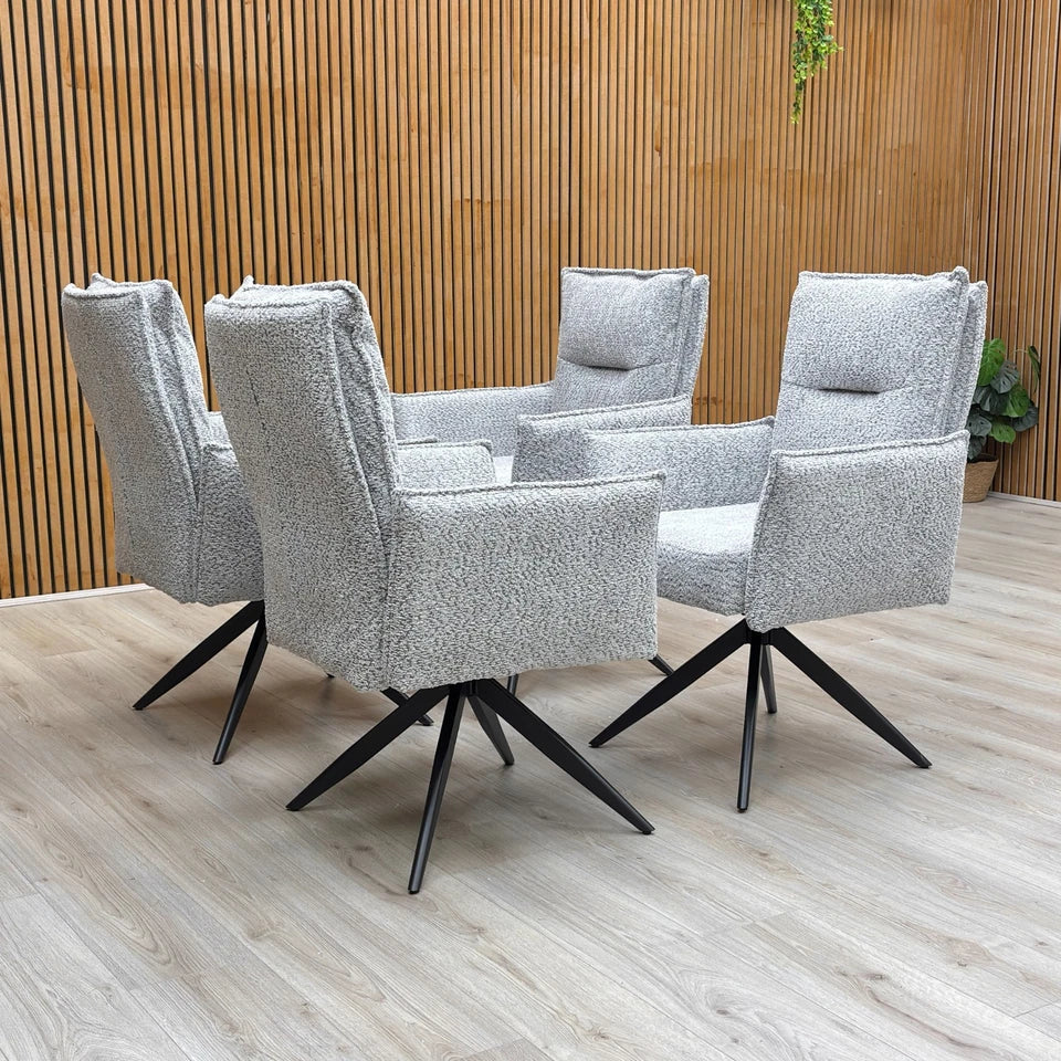 A set of four ‘Sarah’ Light Grey Chenille Swivel Dining Chairs arranged around a dining table.