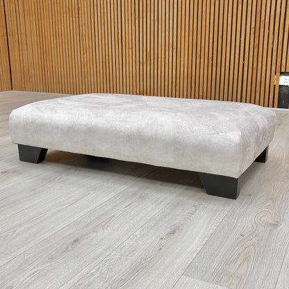 The 'Aura' footstool used as a designer accent piece in a living space.