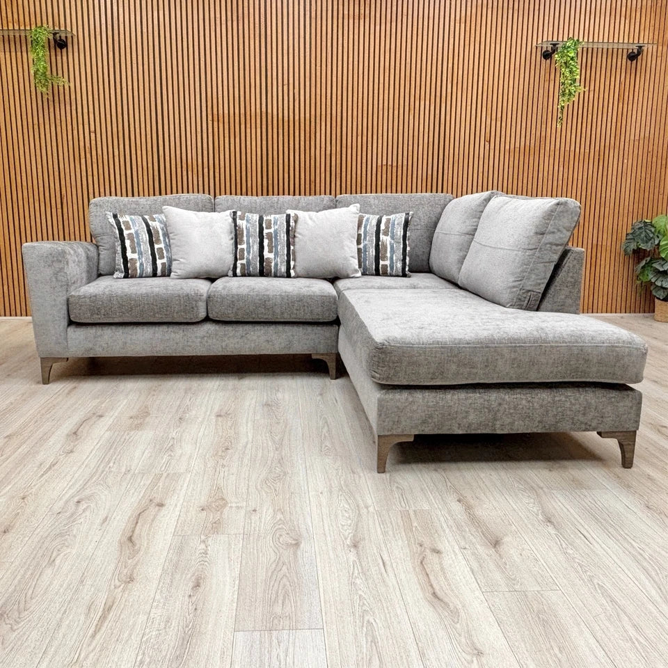 Lifestyle shot of the grey chaise sofa, showing the formal back cushions and open end.