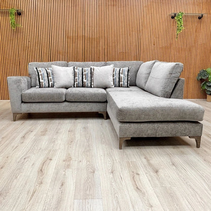 Lifestyle shot of the grey chaise sofa, showing the formal back cushions and open end.