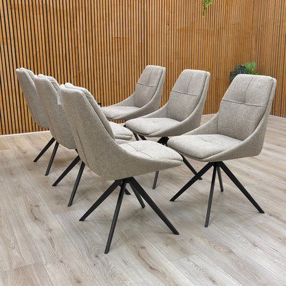 Full-view close-up of a single ‘Jasmine’ Latte Fabric Swivel Dining Chair, highlighting the textured latte fabric and the four-pronged black metal swivel base.