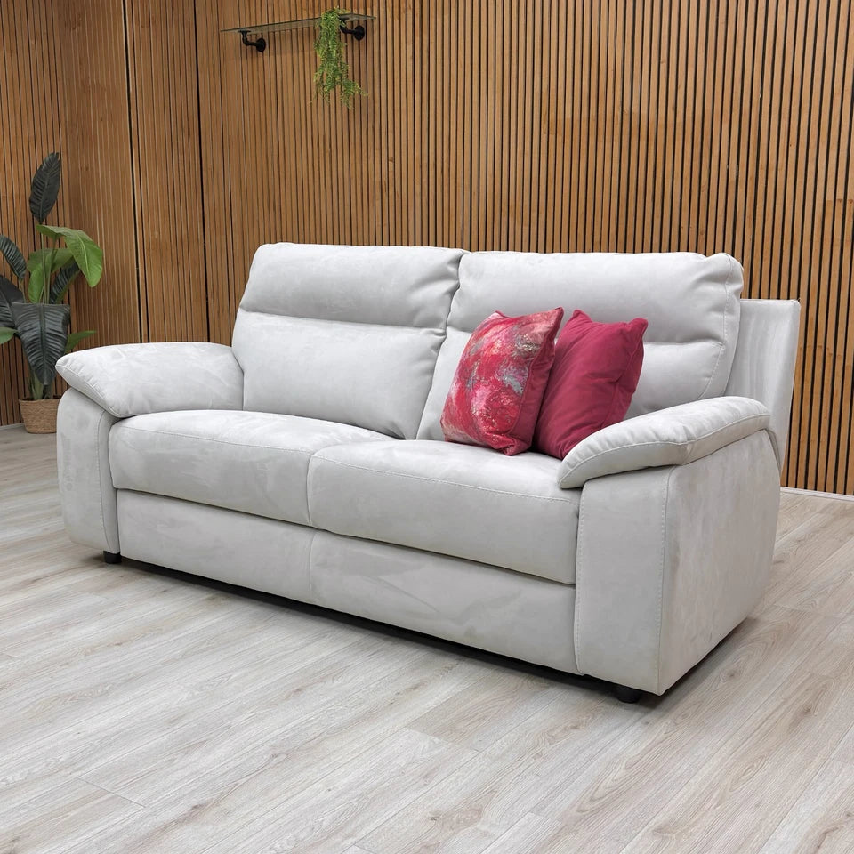 The Nicoletti Pepino sofa in a room setting, showing its sleek profile and the light silver-grey color of the suede-effect fabric.