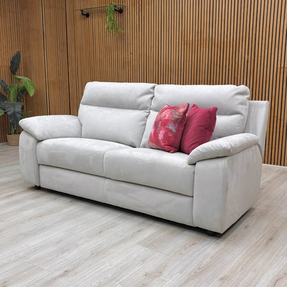 The Nicoletti Pepino sofa in a room setting, showing its sleek profile and the light silver-grey color of the suede-effect fabric.