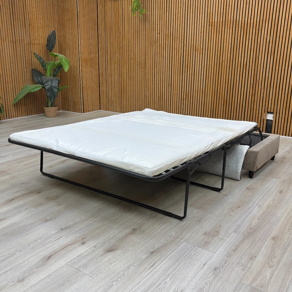 The footstool partially opened, showing the sofa bed mechanism beginning to deploy.