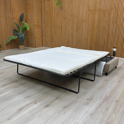 The footstool partially opened, showing the sofa bed mechanism beginning to deploy.