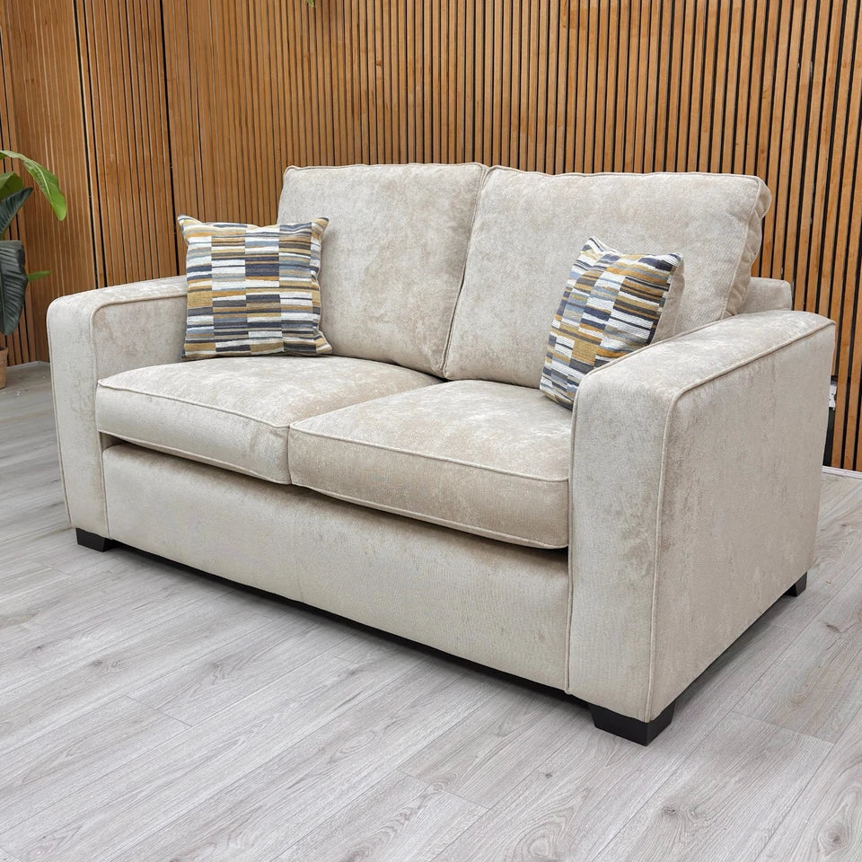 Side profile of the 'Abberton' sofa, emphasizing the wide, square armrests and light-colored fabric.