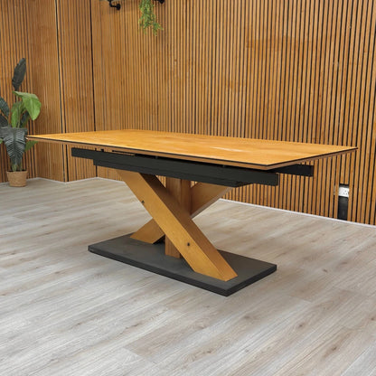 Wooden desk with black metal base against a wooden wall.