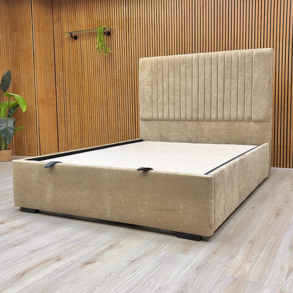 Beige upholstered bed with a wooden wall and plants in the background