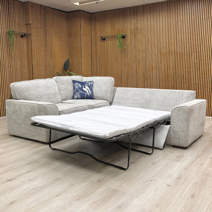 Gray sectional sofa with a pull-out bed in a room with wooden walls.