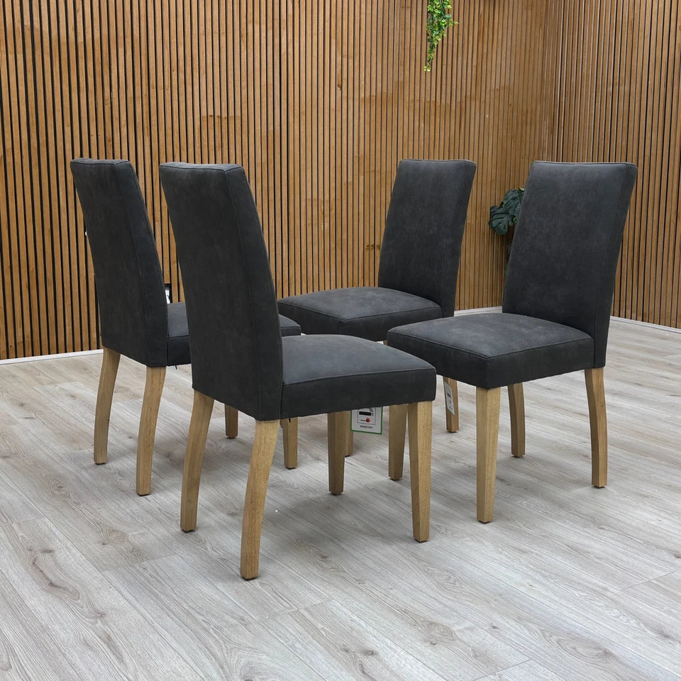 Three-quarter angled view of the grey upholstered 'Augusta' dining chair, highlighting the high, comfortable back and modern country style.