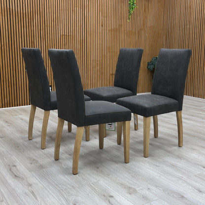 Three-quarter angled view of the grey upholstered 'Augusta' dining chair, highlighting the high, comfortable back and modern country style.