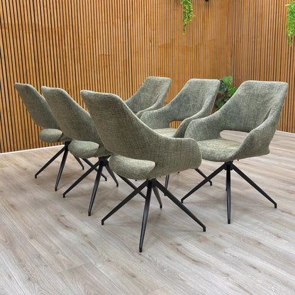 A set of six ‘Charlotte’ Sage Green Tweed Swivel Dining Chairs arranged around a modern dining table.