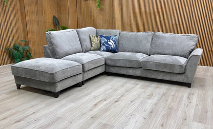 Lifestyle shot of the ‘Legend’ Kingston Grey fabric corner sofa in a modern lounge, highlighting its spacious seating and contemporary style.