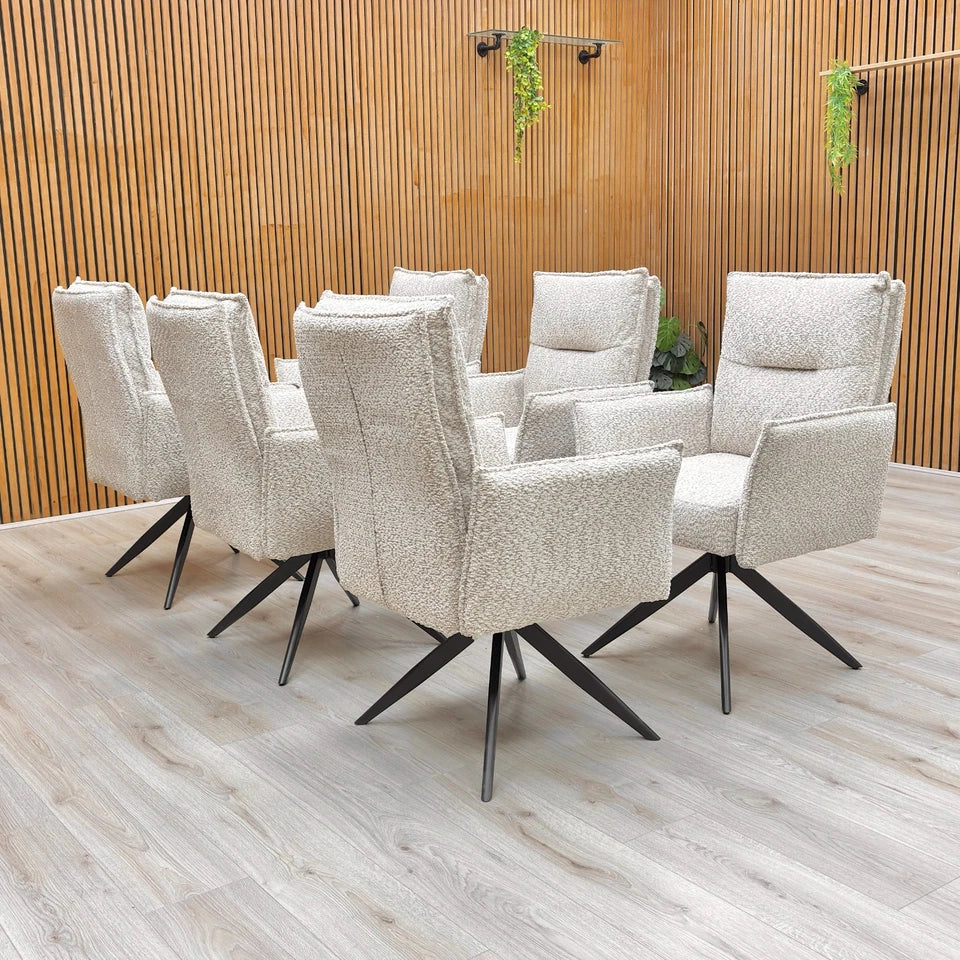 The 'Sarah' dining chair set around a dining table, highlighting its scale and stylish appearance.