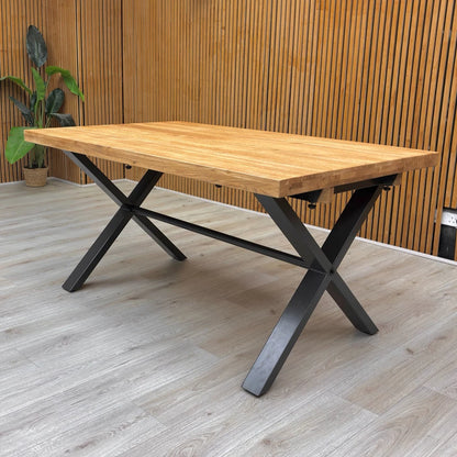 Lifestyle photo of the solid oak table in a rustic dining room setting, highlighting its industrial aesthetic.