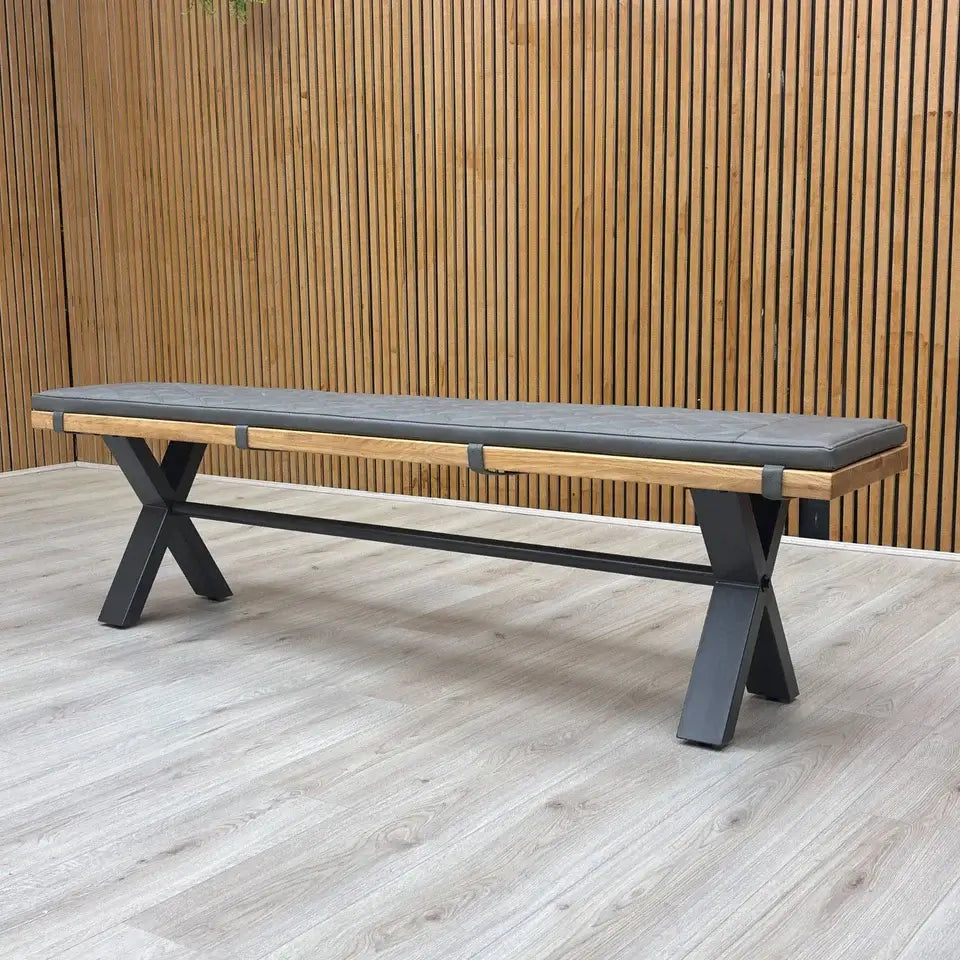 Long bench with wooden seat and metal frame against a wooden panel background