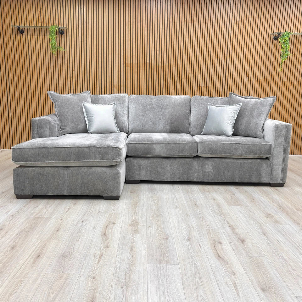 Lifestyle shot of the grey 'Chelsea' corner sofa in a modern living room, highlighting the spacious chaise section.