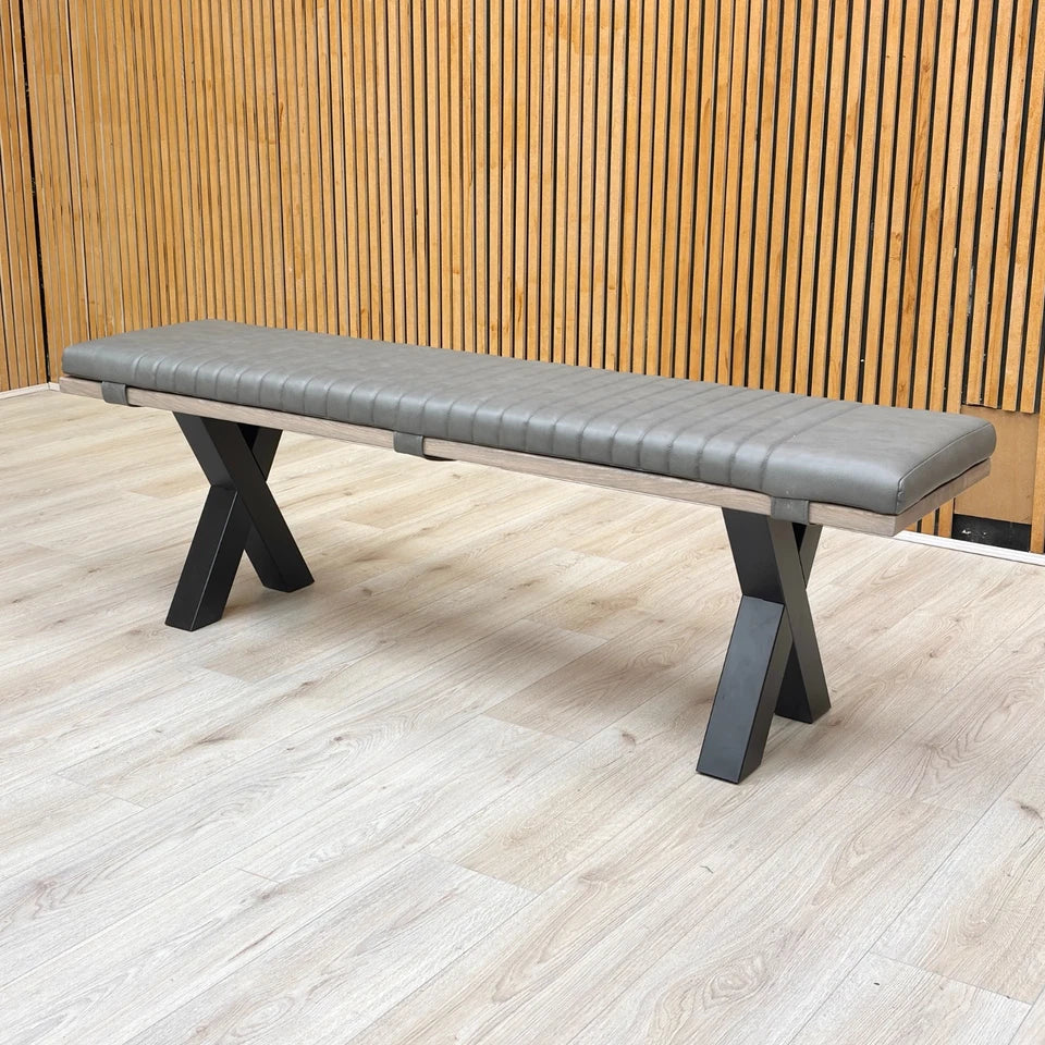 Detail of the grey faux leather bench pad, showing the stitching and secure fit on the oak base.