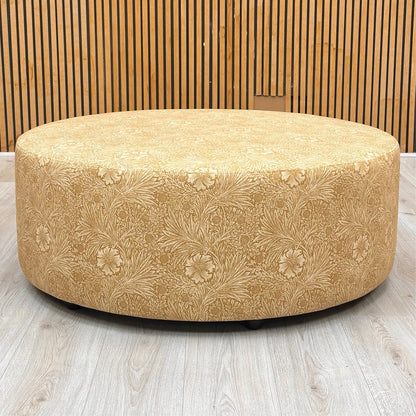 Front view of the Iris footstool, highlighting the rich yellow velvet fabric and the intricate floral pattern details.