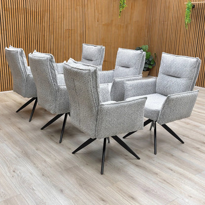 A set of six ‘Sarah’ Light Grey Chenille Swivel Dining Chairs arranged around a dining table.