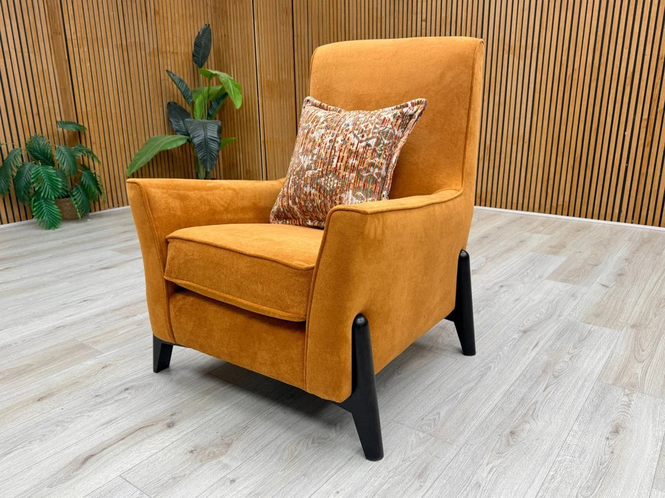Side profile of the 'Collins' accent chair, showcasing the depth, the sloped arms, and the wooden legs beneath.