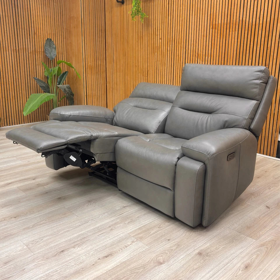 Gray recliner sofa in a room with wooden walls and floor.